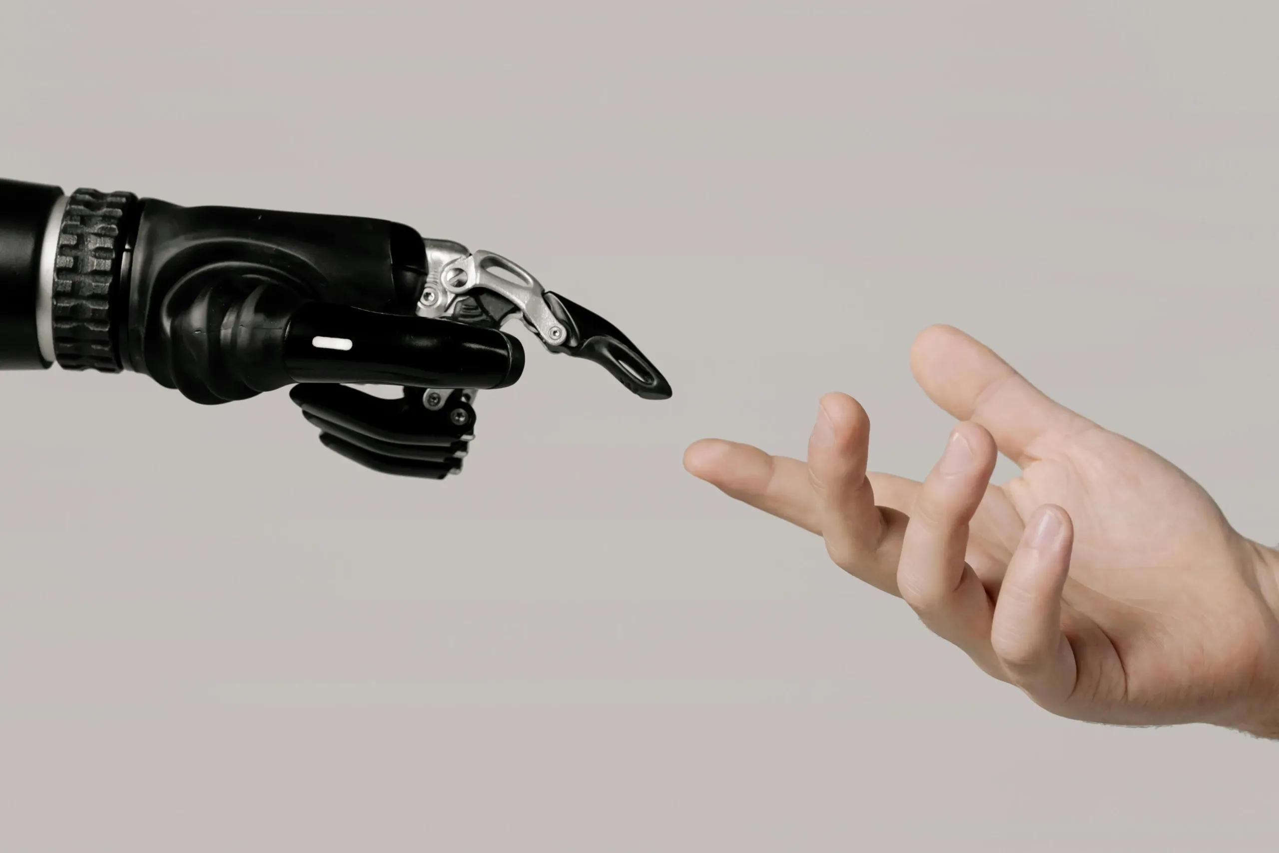 A robotic hand and human hand reaching out, symbolizing artificial intelligence in business.