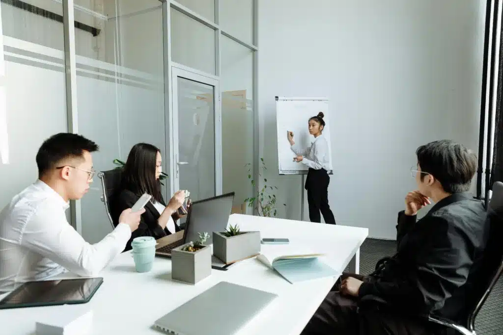 How 3D Animation in Product Marketing is Transforming Businesses in 2025 2 a woman presents at a flip chart while three colleagues sit at a conference table
